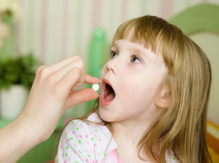 20931199 - child receiving pill - closeup