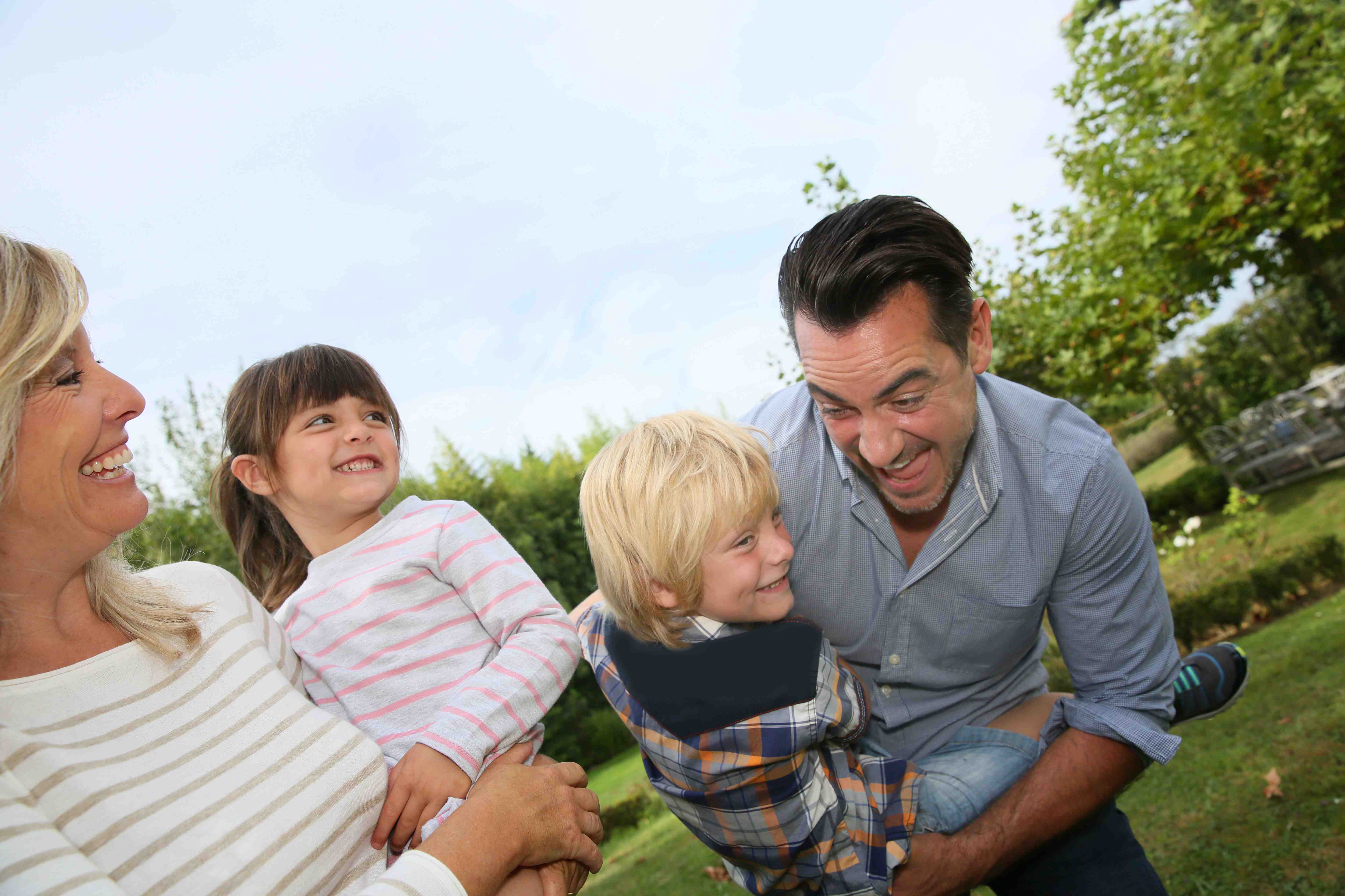 Happy family of four having fun outside