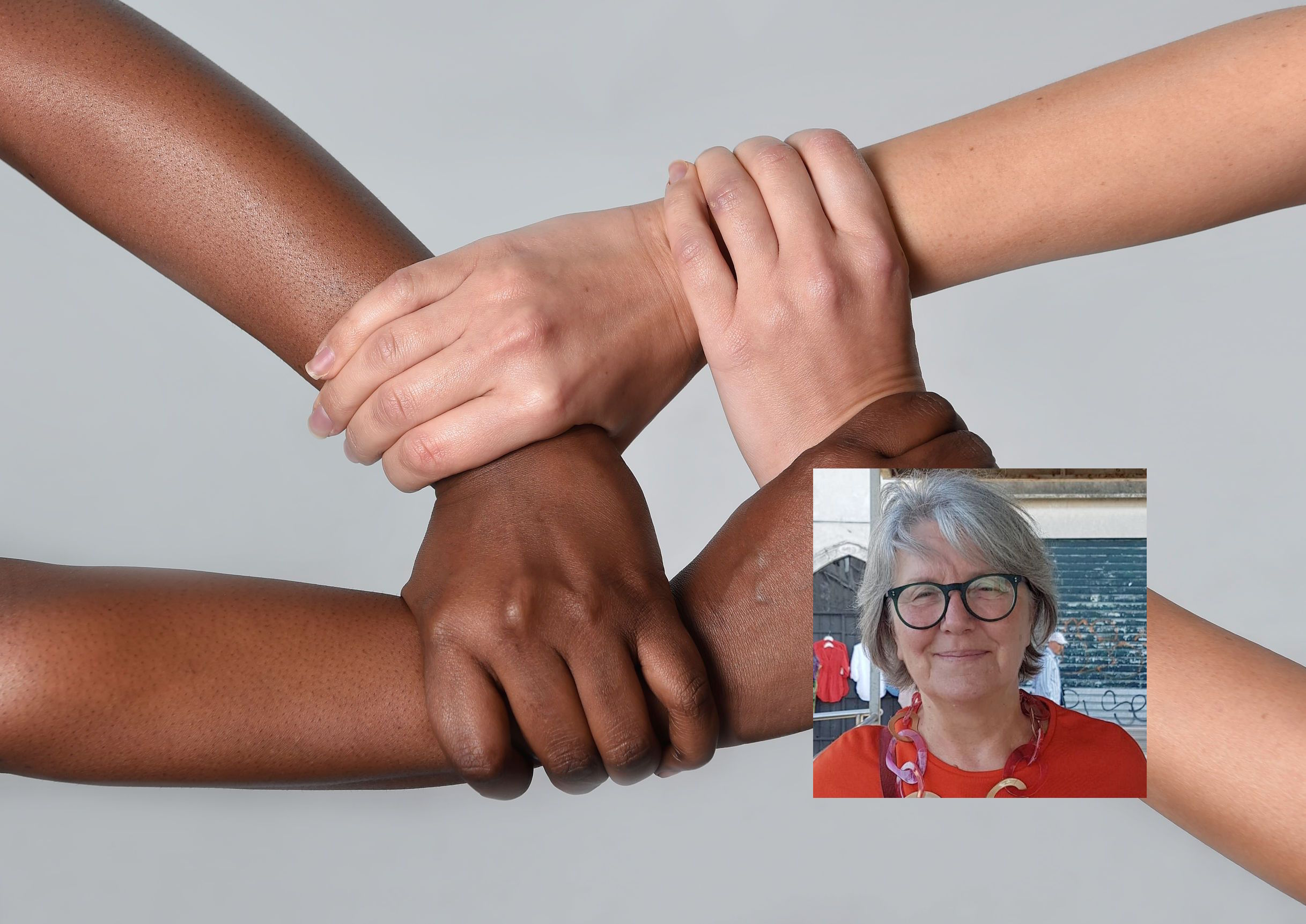 white Caucasian female and black African American hands holding together against racism and xenophobia