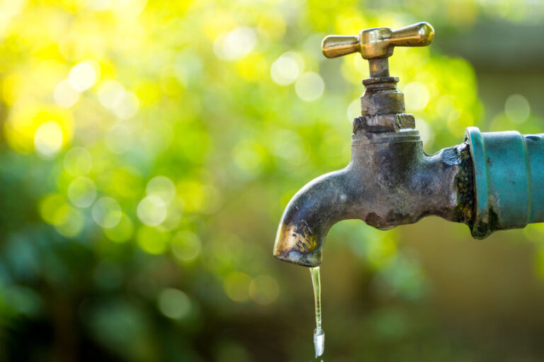 Brass water tap in nature background.