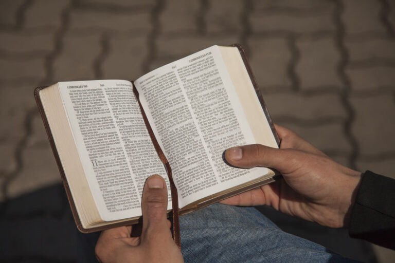 Young man holding and reading holy bible