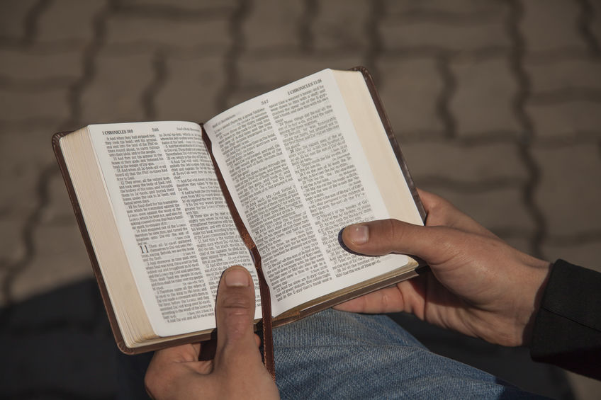 Young man holding and reading holy bible