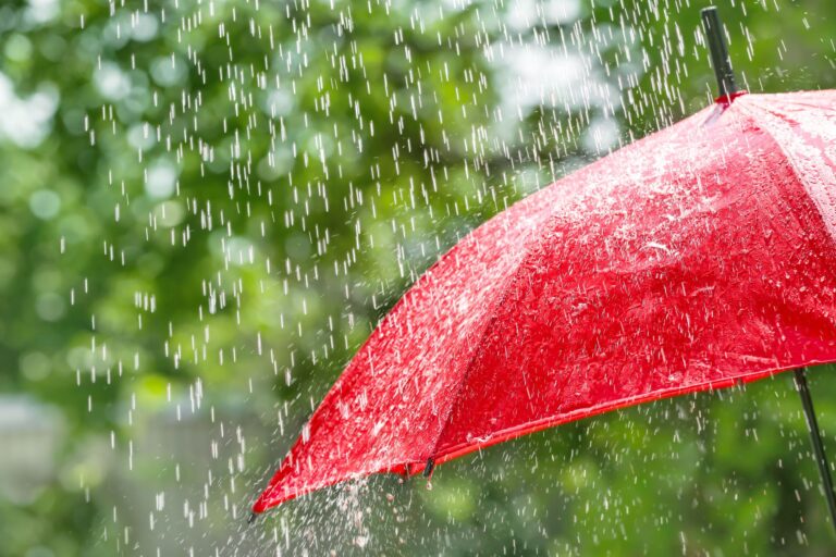 Red umbrella outdoors on rainy day
