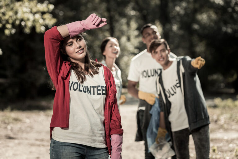 Dark-haired girl wearing pink gloves feeling tired after volunteering all day