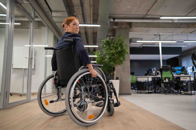 Caucasian woman wheelchair in open space office.
