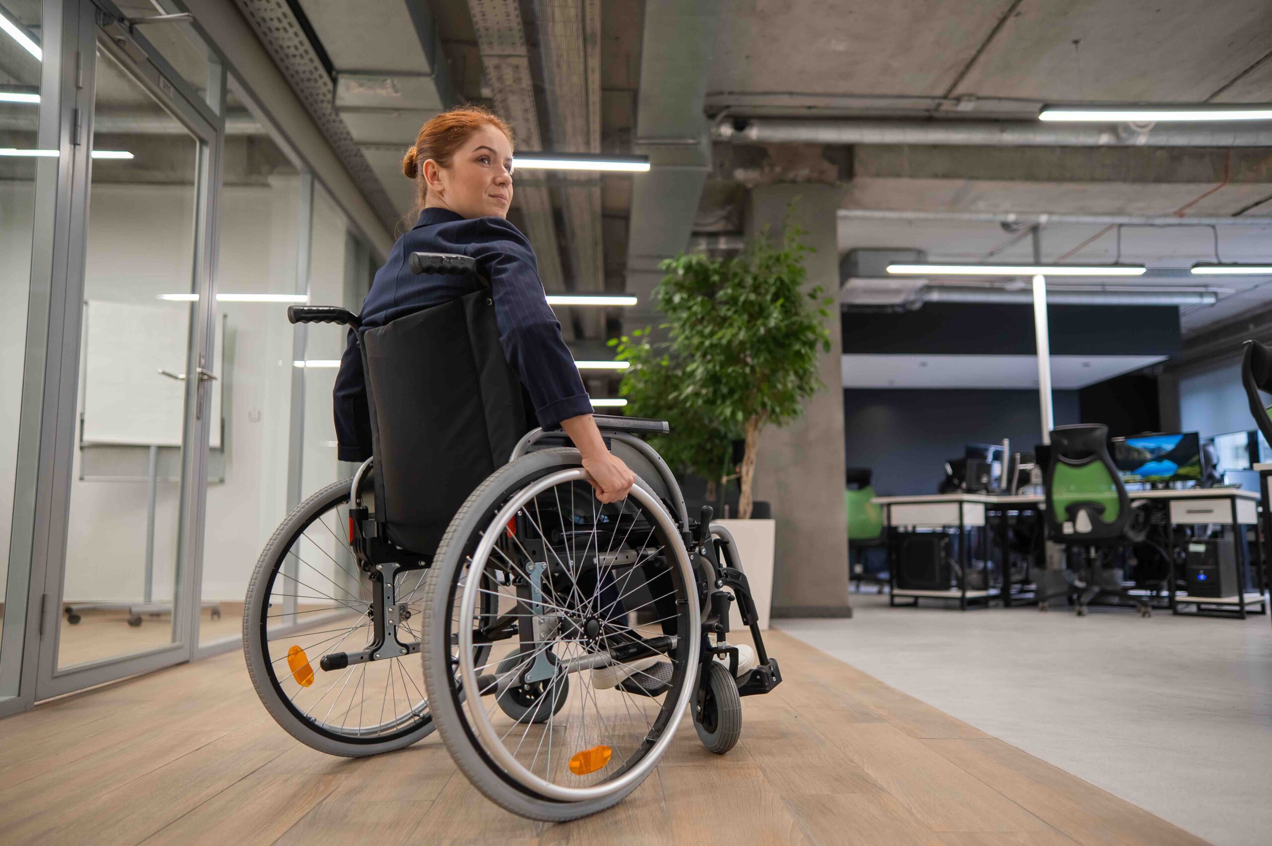 Caucasian woman wheelchair in open space office.