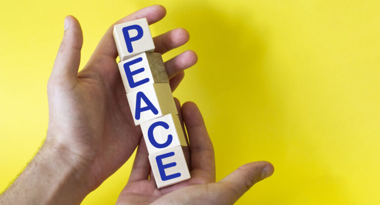hands hold cubes on a yellow background with the words PEACE . Need help and support, the truth will win