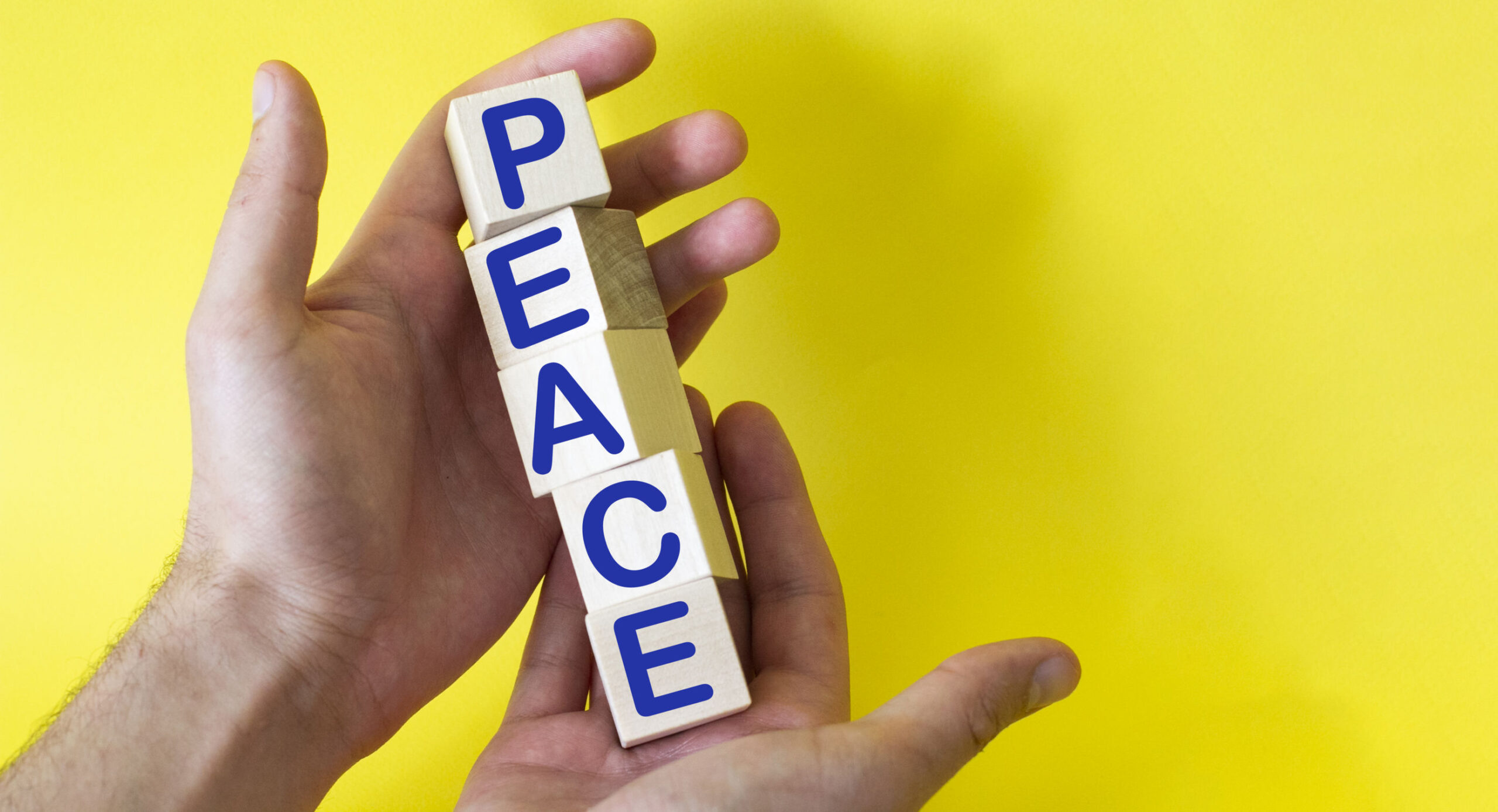 hands hold cubes on a yellow background with the words PEACE . Need help and support, the truth will win