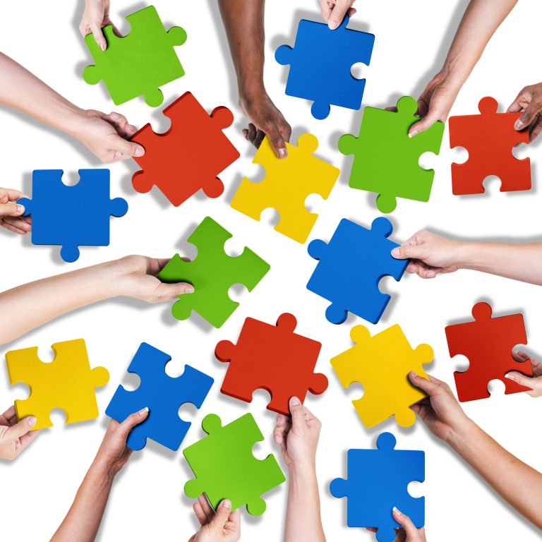 34574778 - group of diverse hands holding jigsaw puzzle